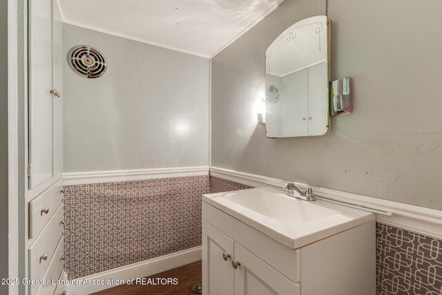 635 Division St, East Lansing, MI 48823 - bathroom featuring vanity, ornamental molding, and wainscoting