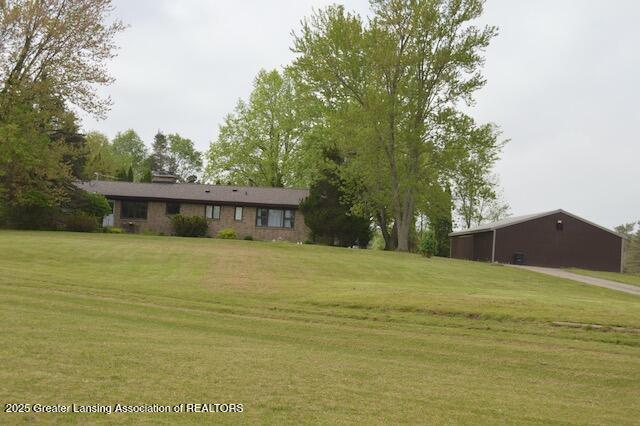 6157 W Stoll Rd, Lansing, MI 48906 - view of grassy yard featuring an outbuilding and an outdoor structure