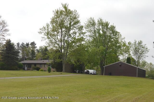 6157 W Stoll Rd, Lansing, MI 48906 - view of green lawn with an outbuilding and view of scattered trees