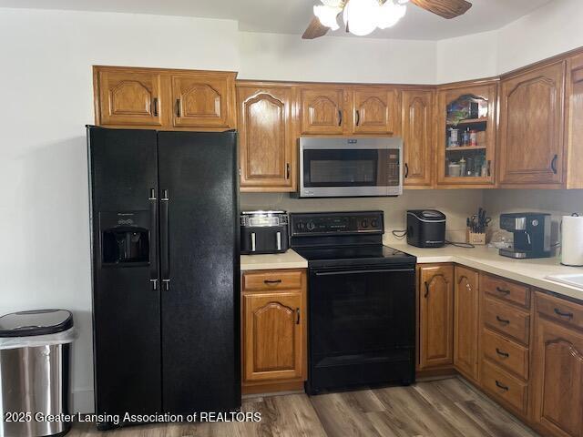 6157 W Stoll Rd, Lansing, MI 48906 - kitchen featuring black appliances, brown cabinets, light countertops, and a ceiling fan