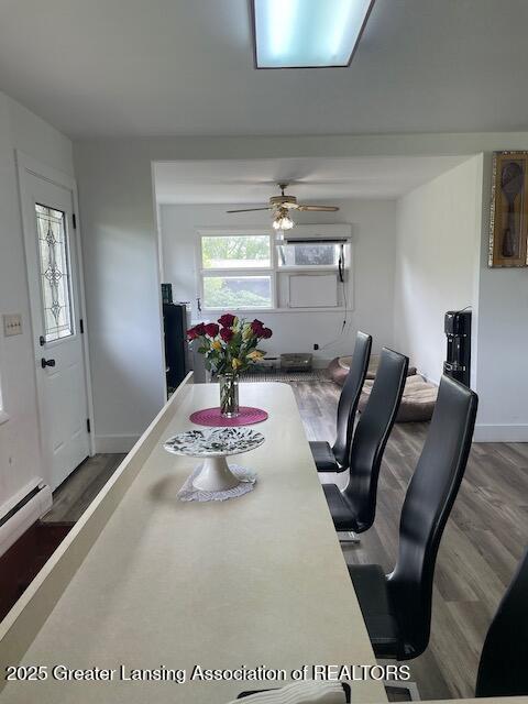 6157 W Stoll Rd, Lansing, MI 48906 - dining space with wood finished floors, a ceiling fan, a desk, and baseboards