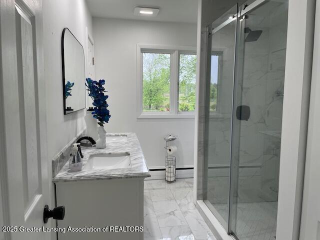 6157 W Stoll Rd, Lansing, MI 48906 - full bathroom featuring marble look tile flooring, double vanity, and a marble finish shower