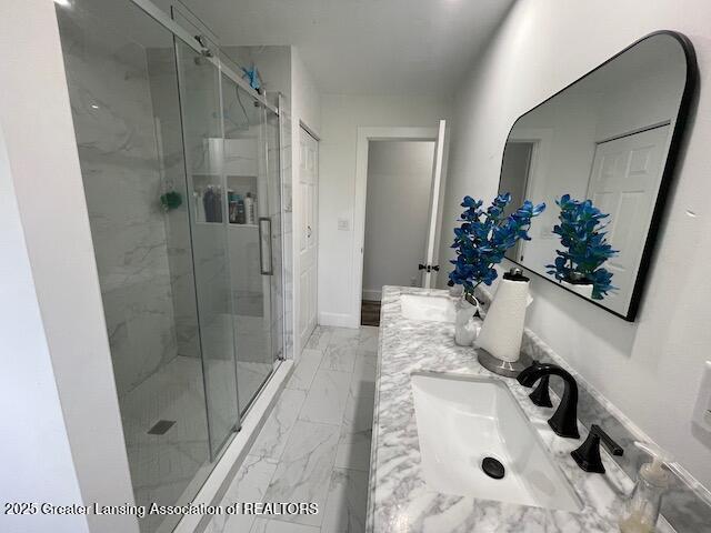 6157 W Stoll Rd, Lansing, MI 48906 - bathroom featuring double vanity, marble finish floors, and a marble finish shower