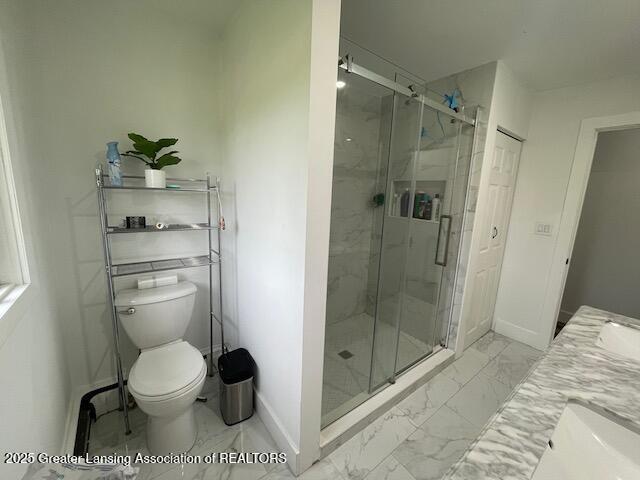 6157 W Stoll Rd, Lansing, MI 48906 - full bathroom featuring marble finish flooring, a marble finish shower, double vanity, and toilet