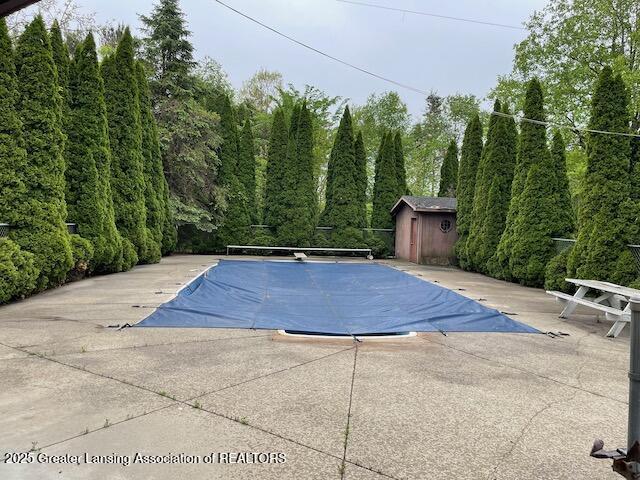 6157 W Stoll Rd, Lansing, MI 48906 - view of pool featuring a patio, a diving board, and a covered pool