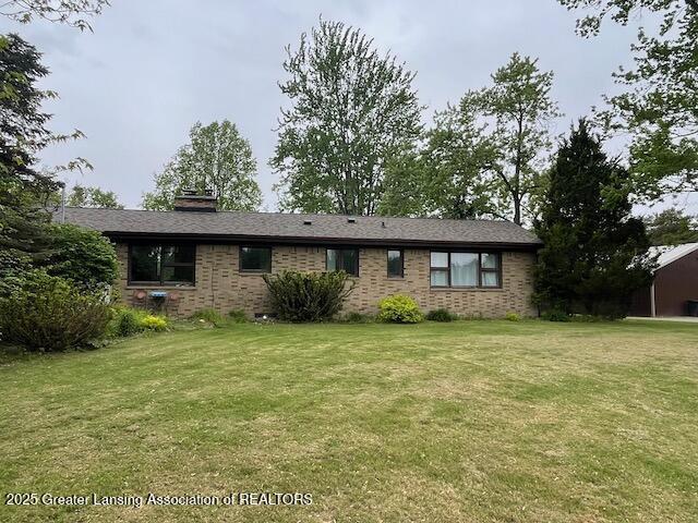 6157 W Stoll Rd, Lansing, MI 48906 - ranch-style house featuring a front yard, brick siding, and a chimney