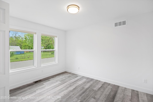 2107 Reo Rd, Lansing, MI 48910 - empty room featuring wood finished floors and baseboards