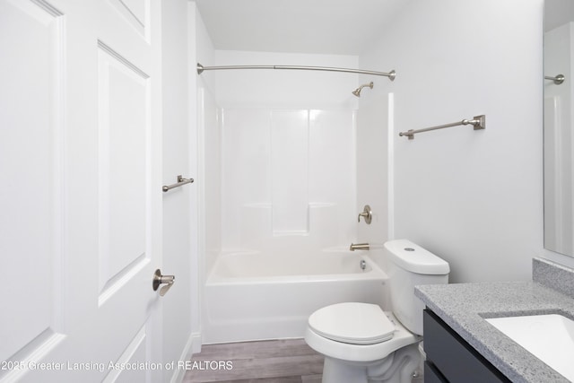 2107 Reo Rd, Lansing, MI 48910 - full bathroom featuring wood finished floors, vanity, toilet, and tub / shower combination