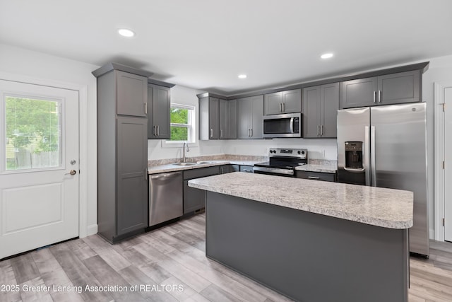 2107 Reo Rd, Lansing, MI 48910 - kitchen with stainless steel appliances, a sink, light countertops, gray cabinetry, and recessed lighting