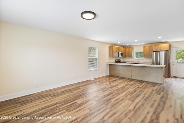 4205 Glenburne Blvd, Lansing, MI 48911 - kitchen with stainless steel appliances, recessed lighting, a peninsula, light wood-style floors, and light countertops