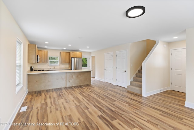 4205 Glenburne Blvd, Lansing, MI 48911 - kitchen with freestanding refrigerator, light wood-type flooring, a peninsula, light countertops, and baseboards
