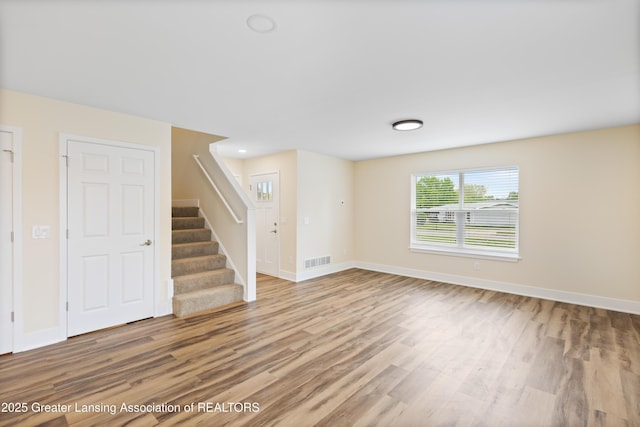4205 Glenburne Blvd, Lansing, MI 48911 - unfurnished living room featuring wood finished floors, stairs, and baseboards