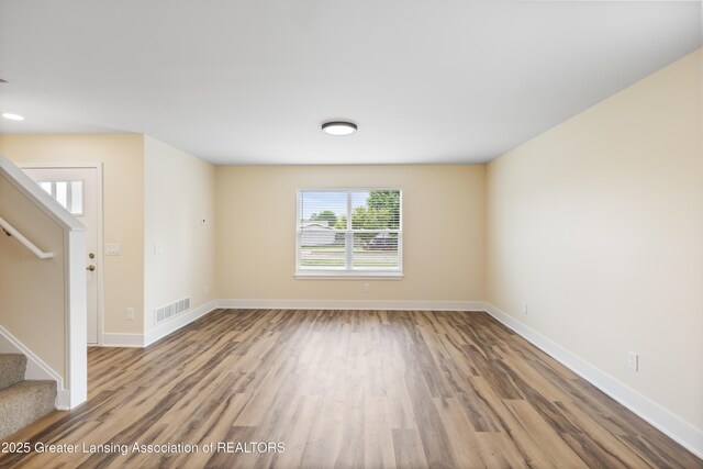 4205 Glenburne Blvd, Lansing, MI 48911 - unfurnished living room featuring stairs, wood finished floors, and baseboards