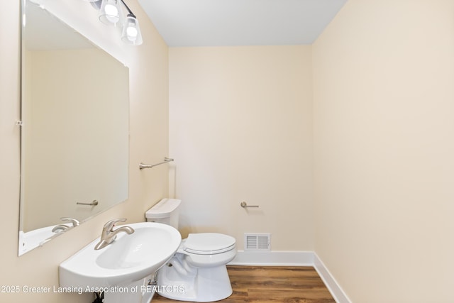 4205 Glenburne Blvd, Lansing, MI 48911 - bathroom featuring toilet, wood finished floors, a sink, and baseboards