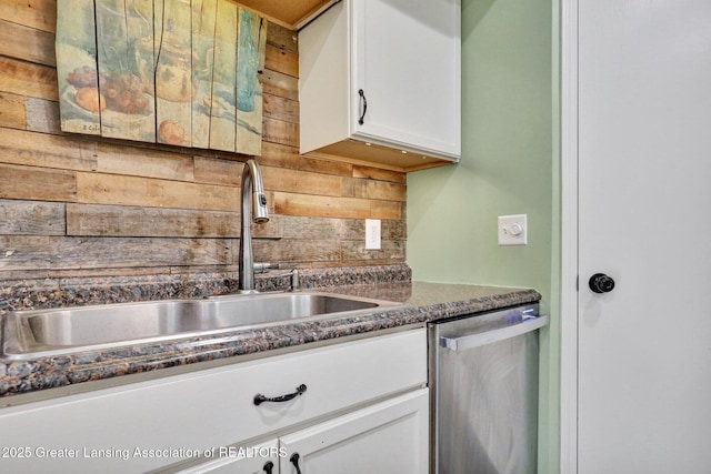 513 E Grand River Rd, Laingsburg, MI 48848 - kitchen featuring a sink, stainless steel dishwasher, backsplash, white cabinets, and wooden walls