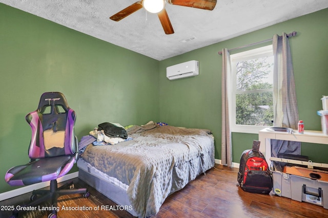 513 E Grand River Rd, Laingsburg, MI 48848 - bedroom with a wall mounted air conditioner, wood finished floors, baseboards, and a ceiling fan