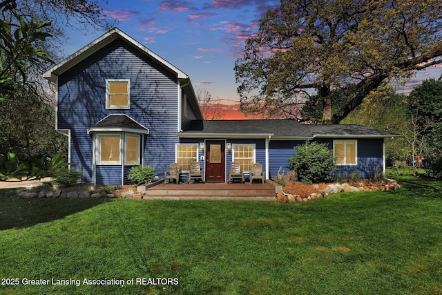 513 E Grand River Rd, Laingsburg, MI 48848 - back of house at dusk with a lawn and a wooden deck