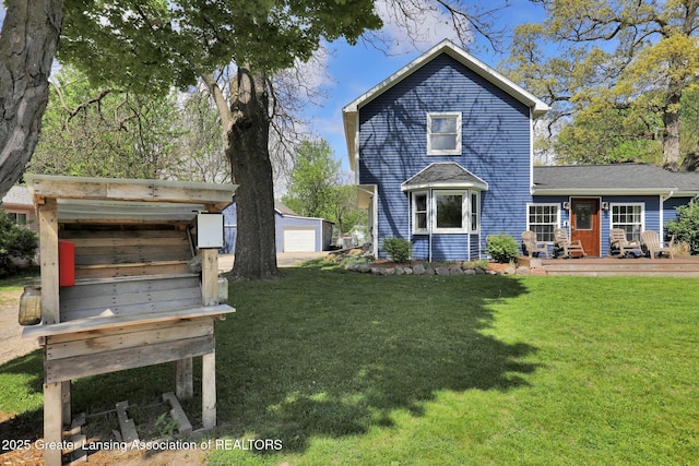513 E Grand River Rd, Laingsburg, MI 48848 - back of property featuring a lawn, a garage, and an outbuilding