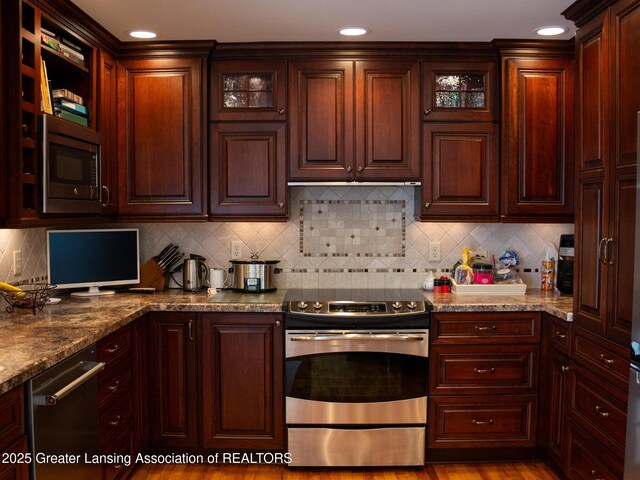 1561 Roseland Ave, East Lansing, MI 48823 - kitchen featuring stainless steel appliances, glass insert cabinets, tasteful backsplash, recessed lighting, and stone counters