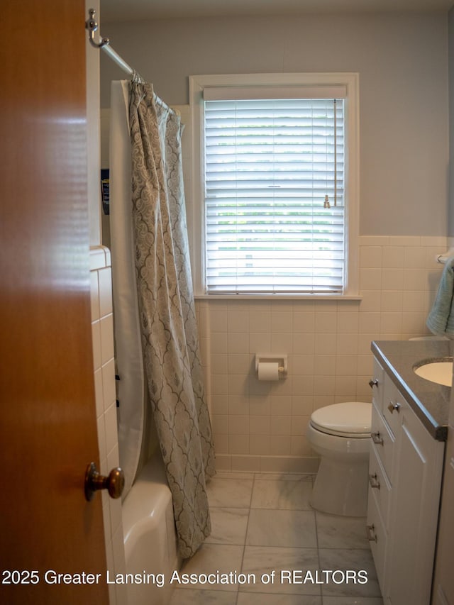 1561 Roseland Ave, East Lansing, MI 48823 - full bathroom featuring tile walls, vanity, toilet, marble finish flooring, and shower / bath combination with curtain