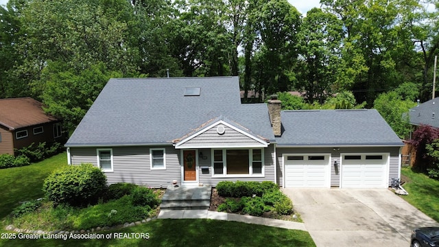 1561 Roseland Ave, East Lansing, MI 48823 - view of front of property with an attached garage, driveway, a chimney, and a front yard