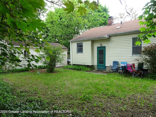 341 W Saginaw St, East Lansing, MI 48823 - back of property featuring a chimney and a yard