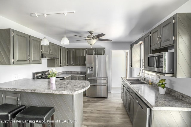 7319 E 5th Point Highway, Eaton Rapids, MI 48827 - kitchen featuring stainless steel appliances, a sink, a peninsula, a ceiling fan, and under cabinet range hood