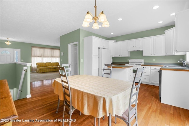 3816 Kiskadee Dr, East Lansing, MI 48823 - kitchen featuring white appliances, a sink, a chandelier, light wood-style floors, and white cabinets