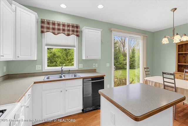 3816 Kiskadee Dr, East Lansing, MI 48823 - kitchen with black dishwasher, a sink, white cabinets, stove, and light wood finished floors
