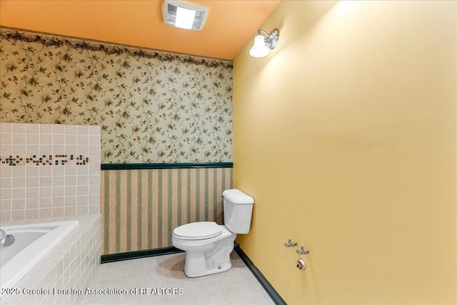 3816 Kiskadee Dr, East Lansing, MI 48823 - bathroom featuring wallpapered walls, toilet, a relaxing tiled tub, baseboards, and a wainscoted wall
