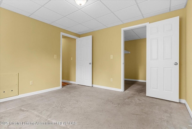 3816 Kiskadee Dr, East Lansing, MI 48823 - unfurnished bedroom featuring baseboards, a paneled ceiling, and a walk in closet