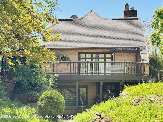 812 Dryer Farm Rd, Lansing, MI 48917 - back of house featuring a deck, a chimney, brick siding, and roof with shingles