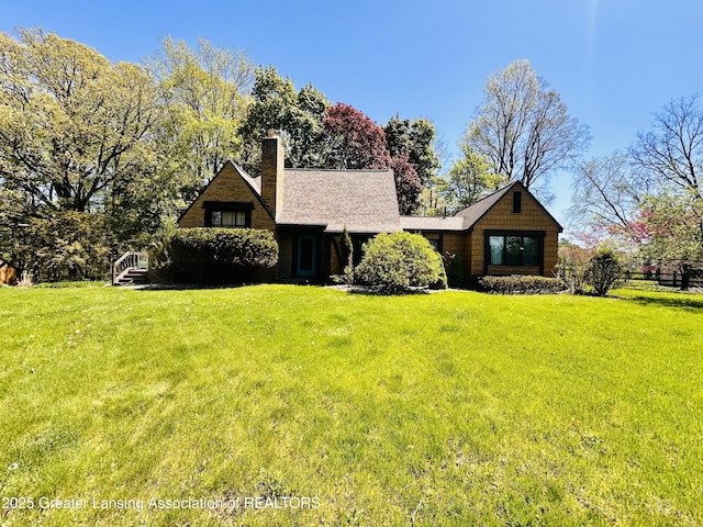 812 Dryer Farm Rd, Lansing, MI 48917 - view of front of property featuring a front lawn, a chimney, and roof with shingles