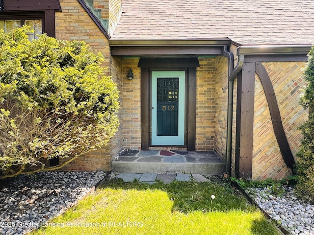 812 Dryer Farm Rd, Lansing, MI 48917 - view of exterior entry with a shingled roof and brick siding
