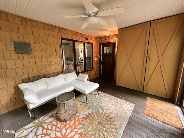 812 Dryer Farm Rd, Lansing, MI 48917 - living area with hardwood / wood-style floors, a ceiling fan, wooden walls, and concrete block wall