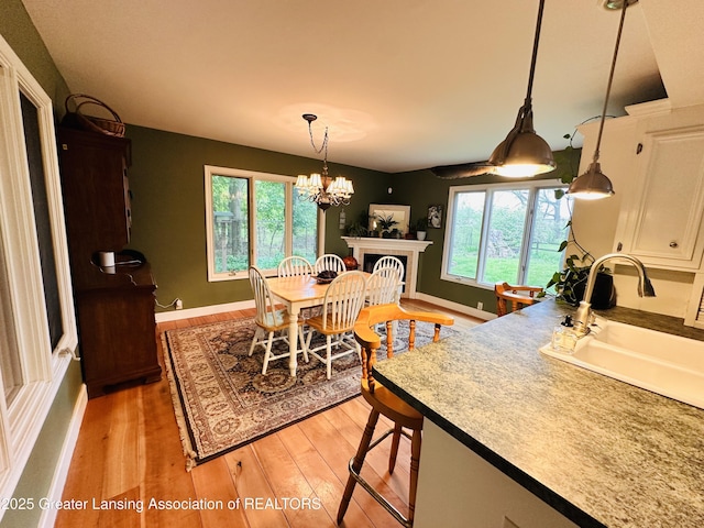 812 Dryer Farm Rd, Lansing, MI 48917 - dining space featuring healthy amount of natural light, light wood-style floors, a chandelier, and baseboards