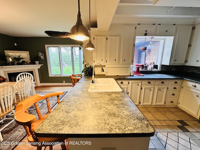 812 Dryer Farm Rd, Lansing, MI 48917 - kitchen featuring a sink, hanging light fixtures, light tile patterned floors, light countertops, and a fireplace