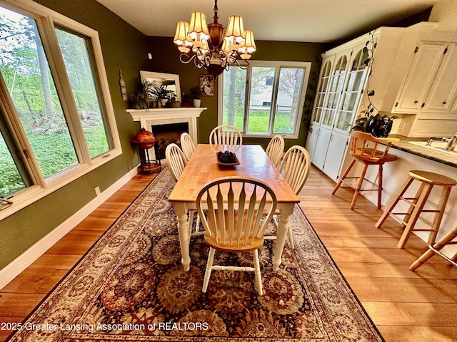 812 Dryer Farm Rd, Lansing, MI 48917 - dining room with plenty of natural light, light wood-style floors, and a chandelier