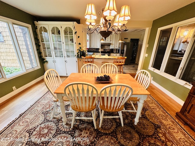 812 Dryer Farm Rd, Lansing, MI 48917 - dining room with a chandelier, baseboards, and light wood-style flooring