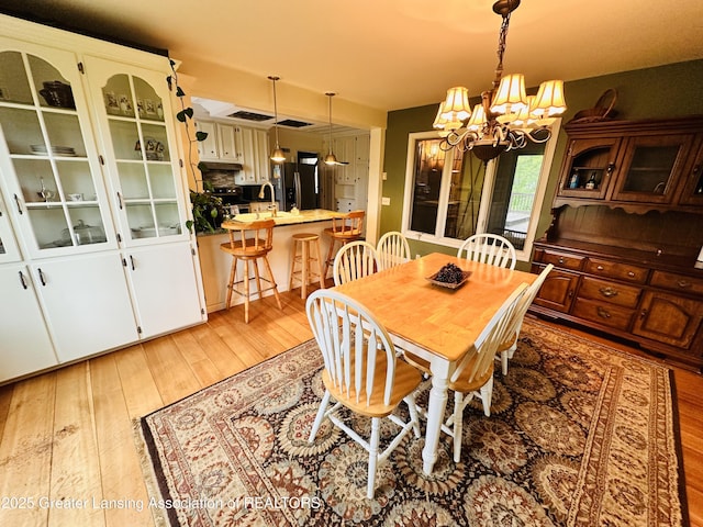 812 Dryer Farm Rd, Lansing, MI 48917 - dining room with a chandelier and light wood-style floors