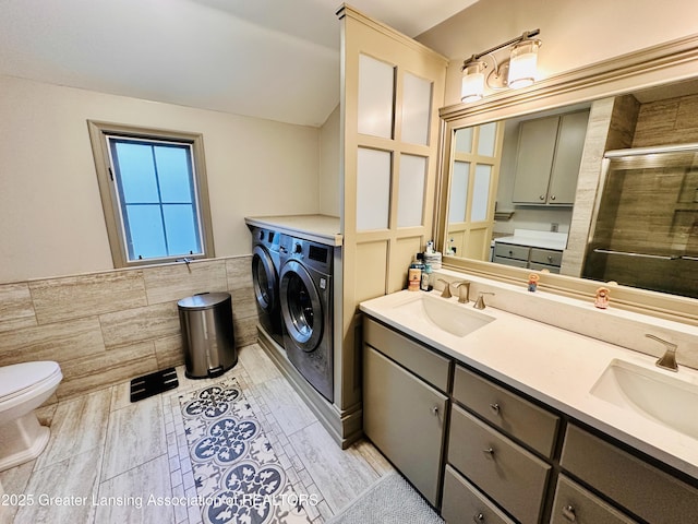 812 Dryer Farm Rd, Lansing, MI 48917 - full bathroom with washer and dryer, tile walls, a shower stall, double vanity, and toilet