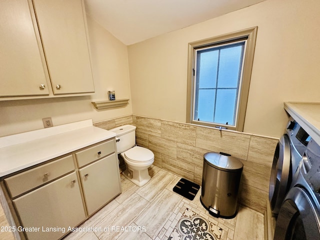 812 Dryer Farm Rd, Lansing, MI 48917 - bathroom featuring tile walls, wainscoting, toilet, washer / clothes dryer, and vanity