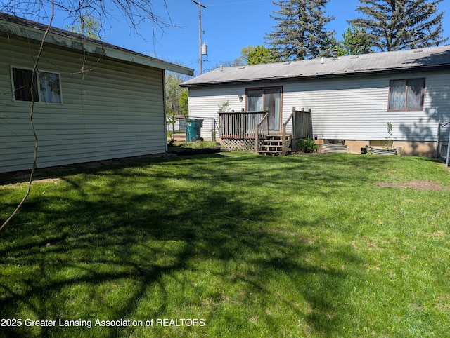 5650 Hughes Rd, Lansing, MI 48911 - rear view of house featuring a wooden deck, a lawn, and central AC