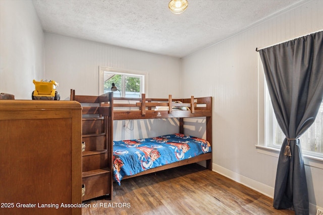 912 Pacific Ave, Lansing, MI 48910 - bedroom with wood finished floors, a textured ceiling, and baseboards