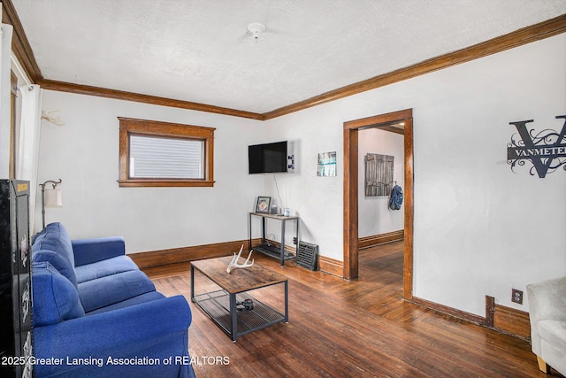living room featuring baseboards, crown molding, wood finished floors, and a baseboard heating unit