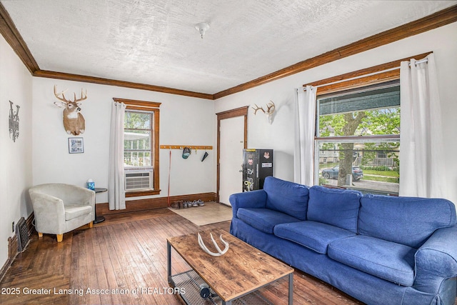 living room with crown molding, hardwood / wood-style floors, baseboards, a textured ceiling, and cooling unit