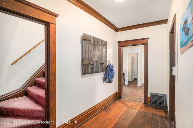 hall with crown molding, wood-type flooring, stairway, and baseboards
