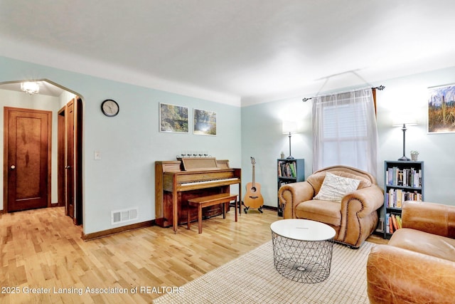 1411 Poxson Ave, Lansing, MI 48910 - living room featuring light wood finished floors, arched walkways, and baseboards