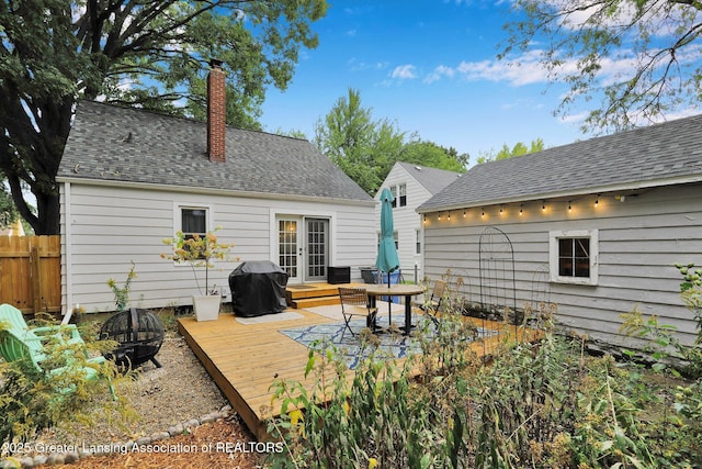 1411 Poxson Ave, Lansing, MI 48910 - back of house with an outdoor fire pit, a wooden deck, french doors, a chimney, and fence