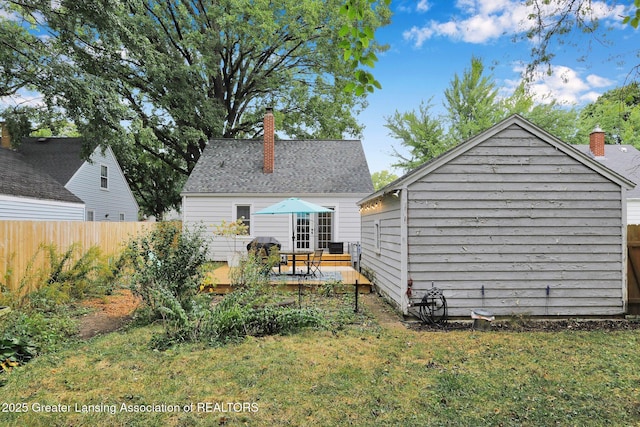 1411 Poxson Ave, Lansing, MI 48910 - rear view of property with a chimney, a wooden deck, and an outbuilding
